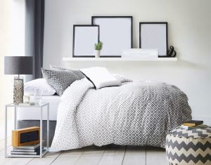 Moderne soveværelse med dynebetræk i grå nuancer.
