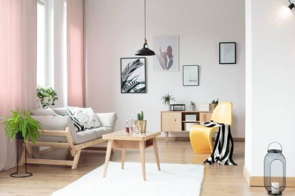 Minimalistisk stue med lyserøde gardiner.