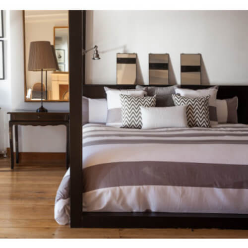 Soveværelse med lilla-stribet sengebetræk.