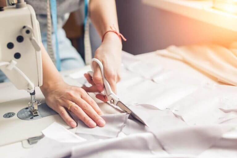 Kvinde klipper stof, som skal syes på symaskinen