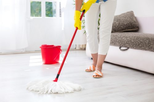 En kvinder mopper gulvet for at rengøre dit hjem