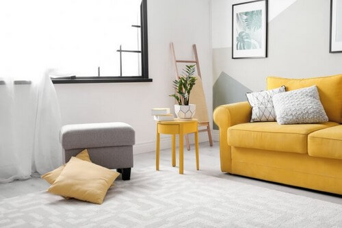 En stue med gul sofa 