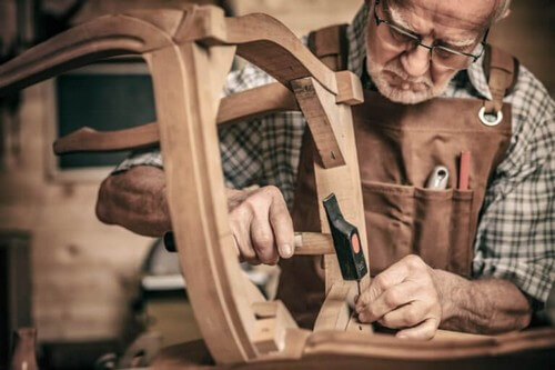 Mand reparerer en gammel stol