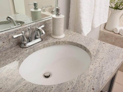 Et badeværelse med bordplade af granit.