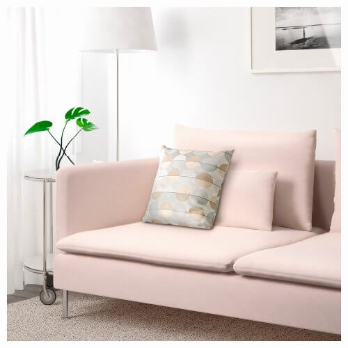 En lys rosa sofa i en stue.