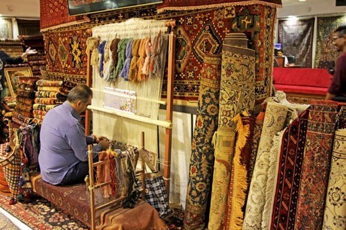 Mand væver persiske tæpper