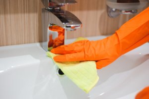 Badezimmer wird von einer Person mit Handschuhen geputzt