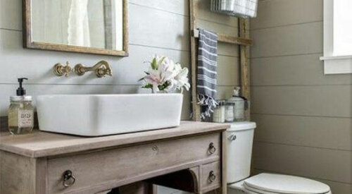 Eine alte Holzleiter findet sich womöglich nicht auf deiner Liste der Dinge, die du dir in deinem Badezimmer wünschst; sie verleiht dem Ambiente jedoch ein besonderes Dekor.