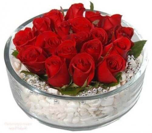 Arrangement aus roten Rosen auf einem Steinbett