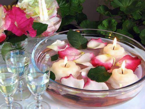 Arrangement aus schwimmenden Blütenblättern und schwimmenden Kerzen