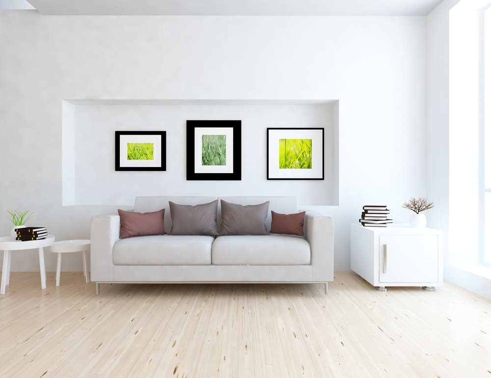 Tres cuadros colocados ordenadamente sobre el sofá