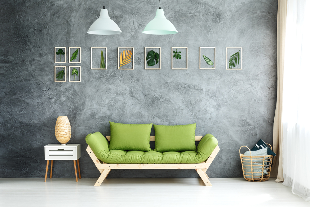 Habitación de estilo tropical sutil: cuadros con plantas, sofá de madera con cojines en verde, cesta de mimbre