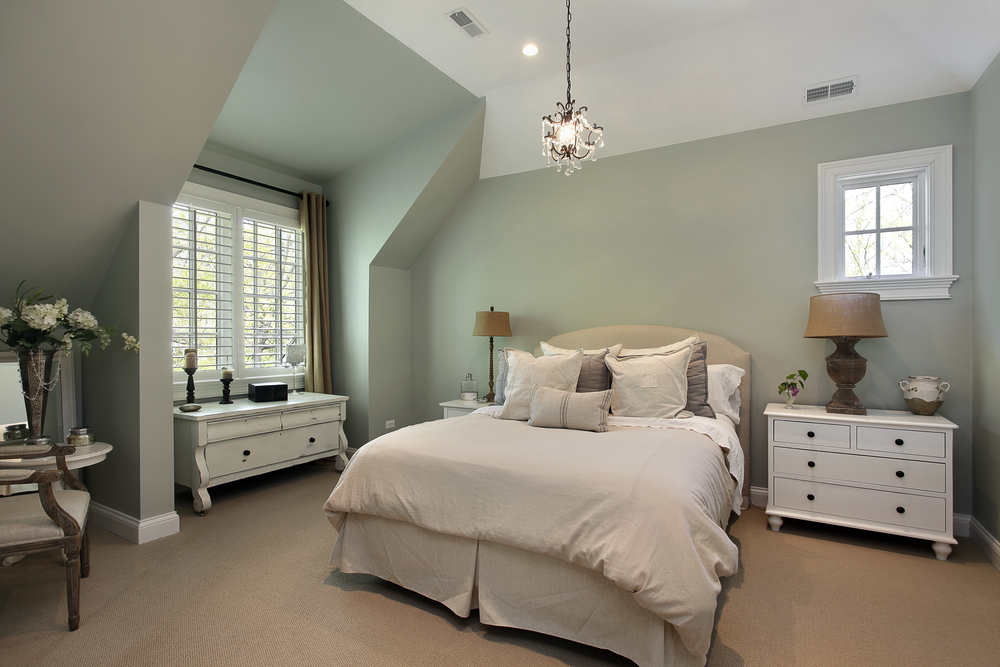 Habitación para invitados: lámparas en las mesillas, armario, pie de cama con toallas.