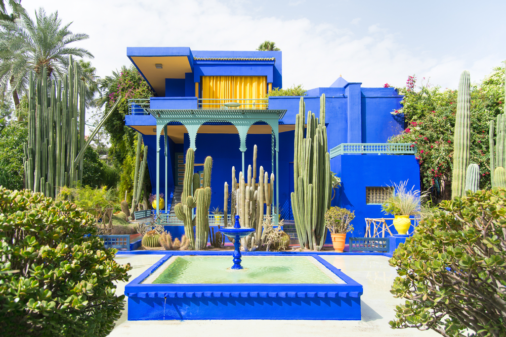 Casa de color azul en contraste con el jardín verde.