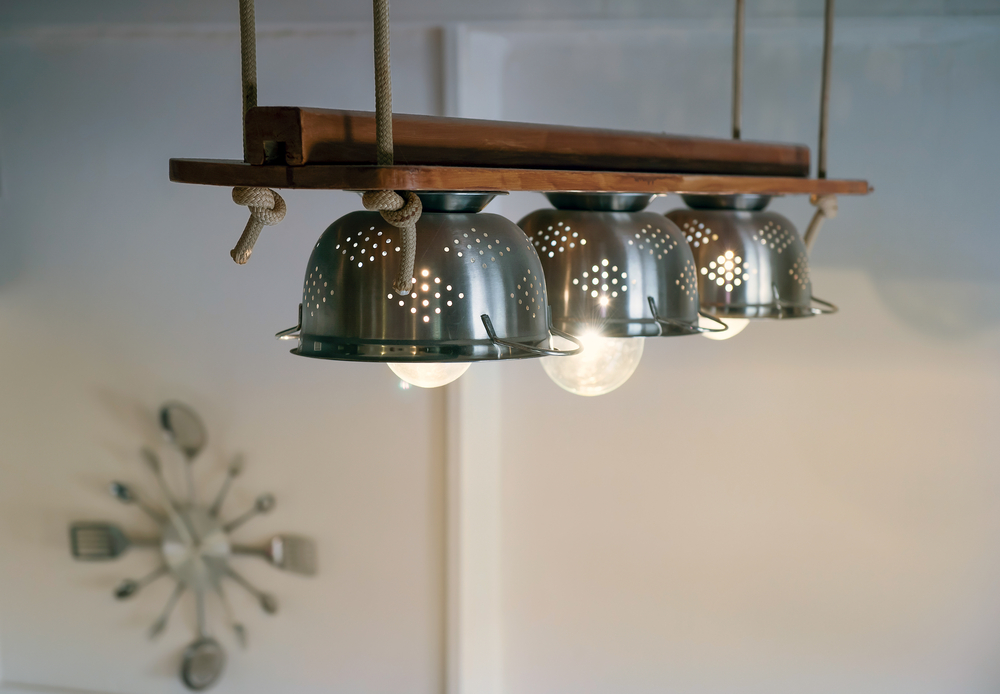 Lámparas trifásicas con forma de farolillo metálico para una cocina de madera
