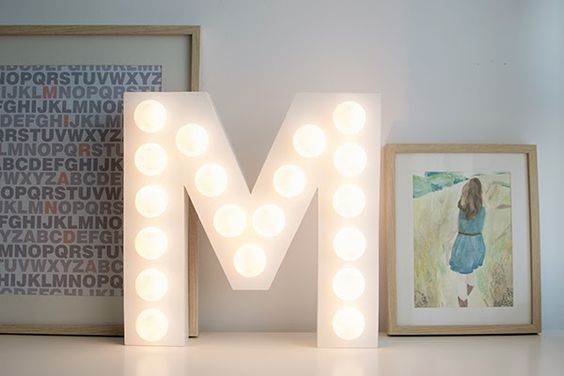 Letra M de cartón con luces LED.