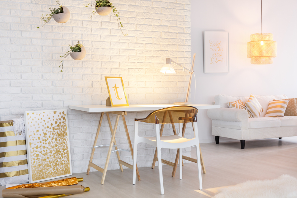 Mobiliario dorado combinado con madera y ladrillo blanco.