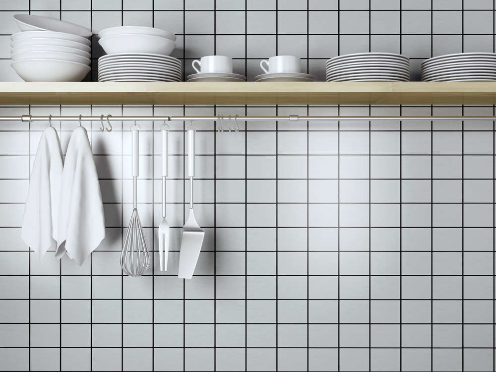 Utensilios de cocina frente a pared con azulejo blanco