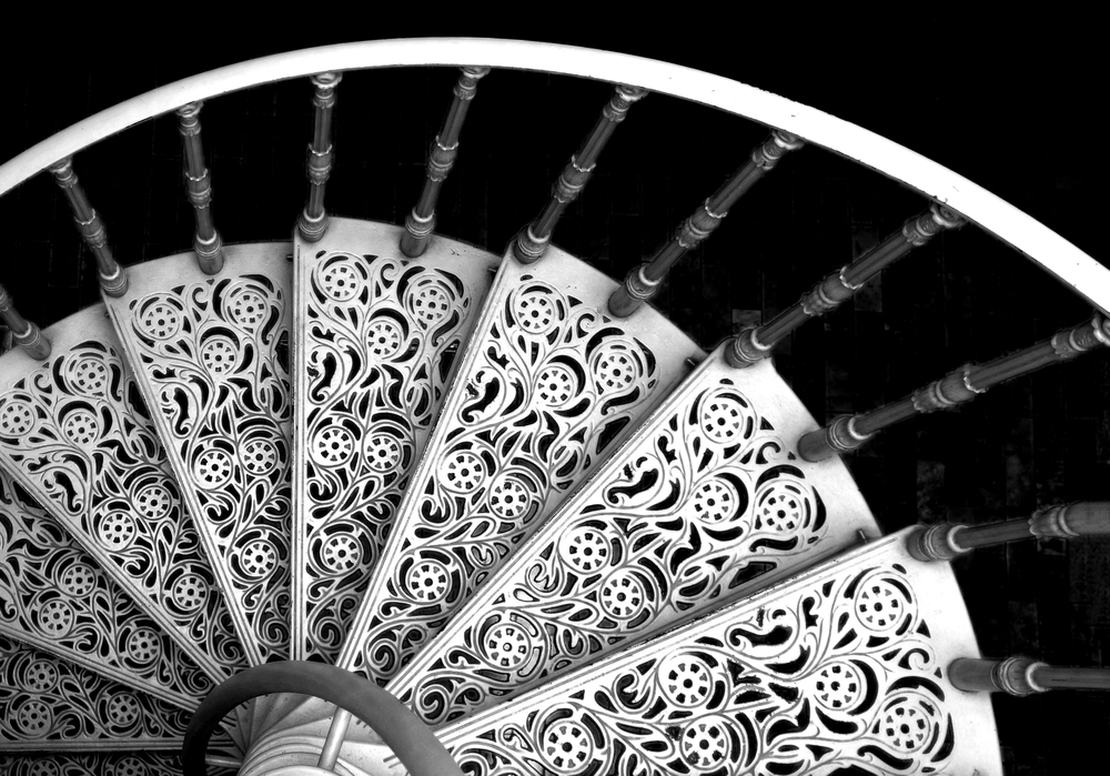An ornate metal spiral staircase with elegant arabesques.