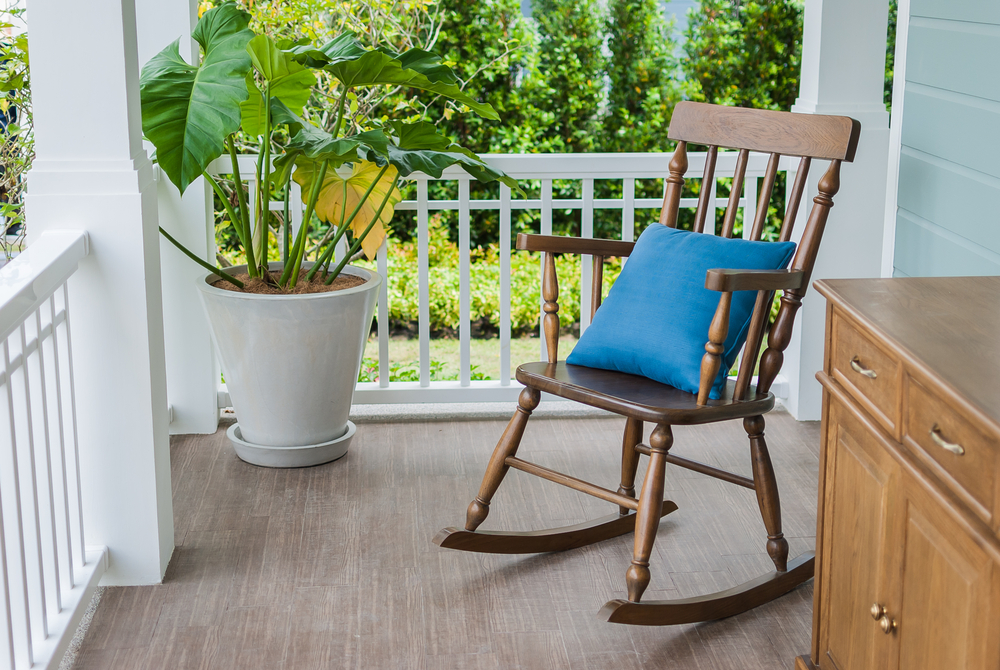 A wooden rocking chair on a porch.