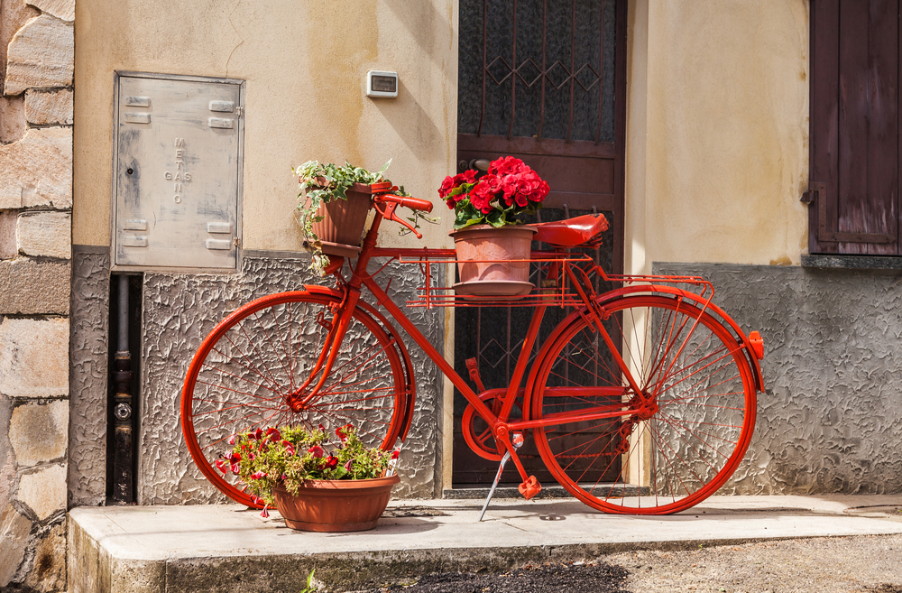 Bicicleta roja con maceteros.