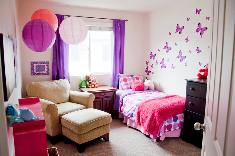 Dormitorio con una pared decorada con mariposas.