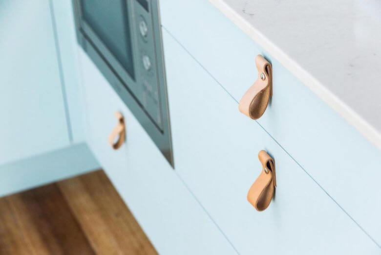 Horizontal leather handles for kitchen drawers.