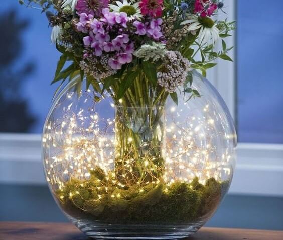 Centro de mesa con luces y flores.