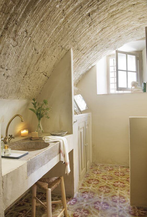 A country bathroom with an arch ceiling and an antique tile floor.