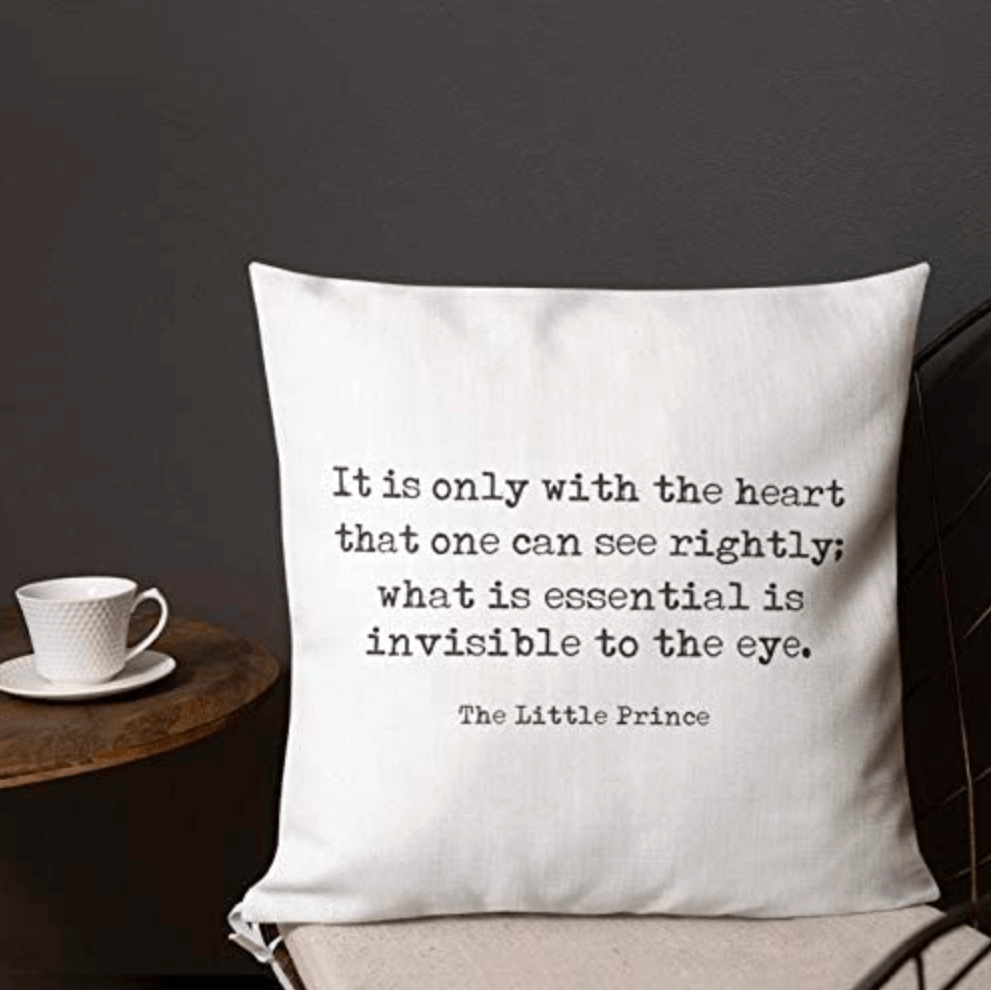 A while pillow with the following text in black letters "It is only with the heart that one can see rightly; what is essential is invisible to the eye. The Little Prince."