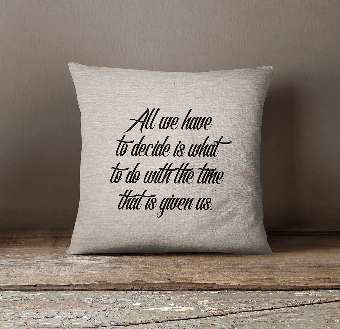 A  gray throw pillow with the phrase "All we have to decide is what to do with the time that is given us" in black letters.