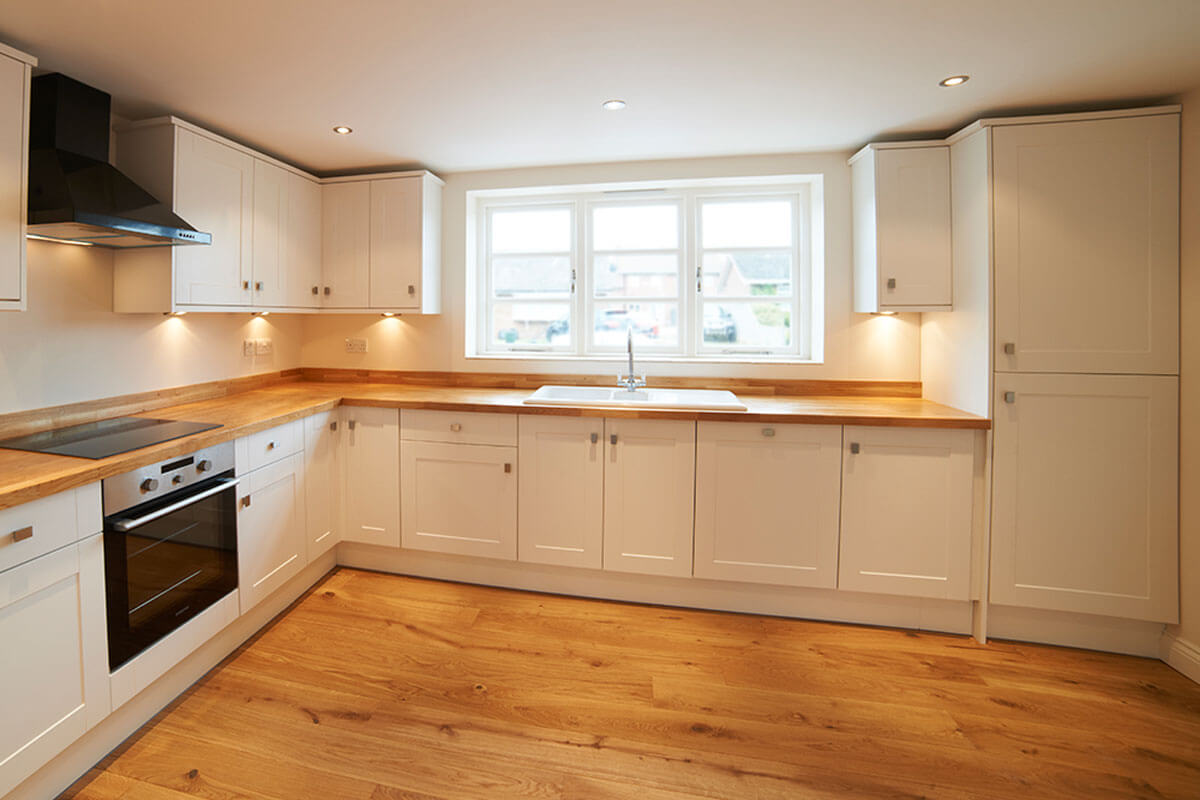 El suelo de madera combina muy bien con las cocinas blancas.
