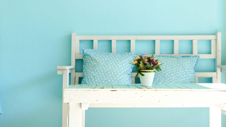 panchina con cuscini e muro azzurro