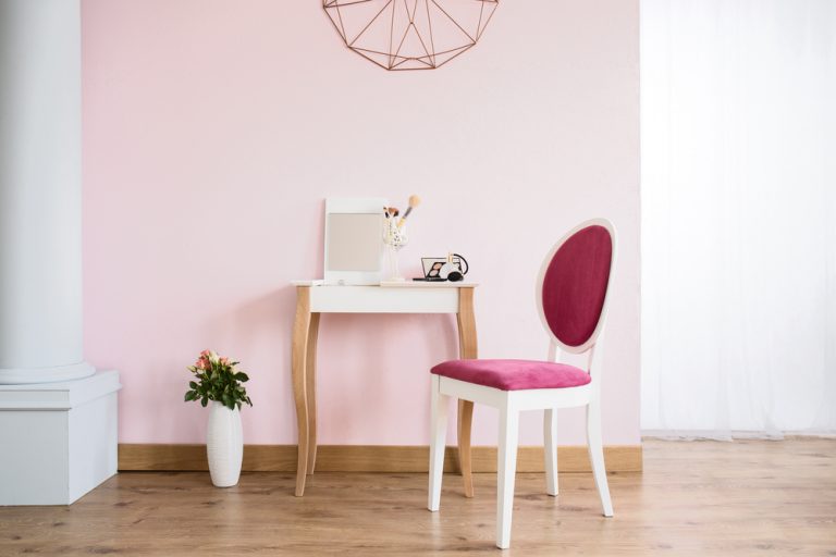 muro rosa con tavolino e sedia
