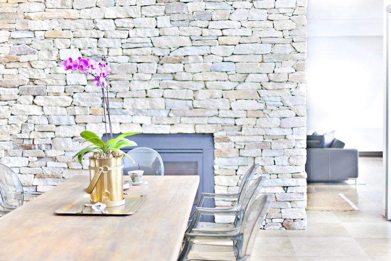 soggiorno con tavolo sedie e muro in pietra