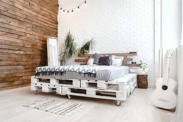 stanza con parete in legno e letto su piattaforme di legno bianche