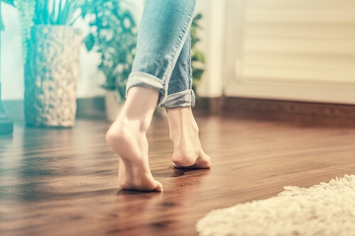 Una ragazza cammina senza scarpe dentro casa