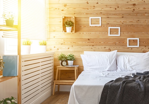 Una camera da letto con cornici e cactus per decorare pareti vuote
