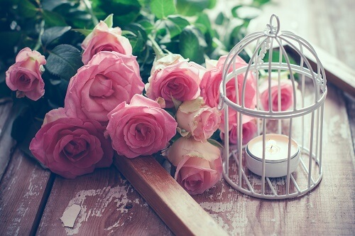 Mazzo di rose accanto a una gabbia decorativa
