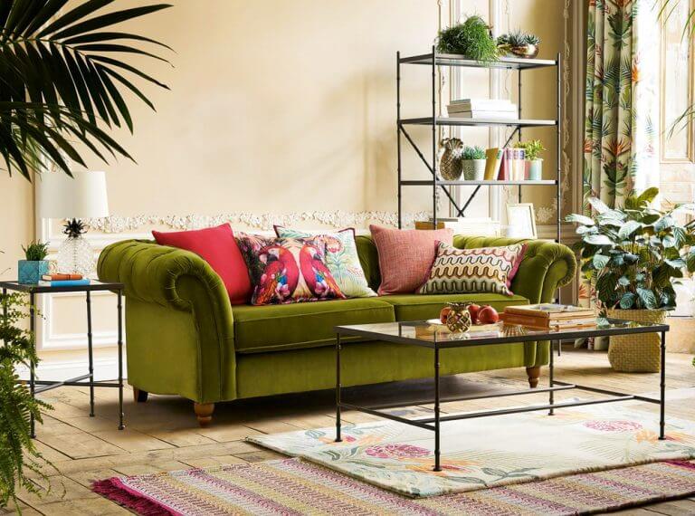 Salotto con divano verde ed elementi naturali