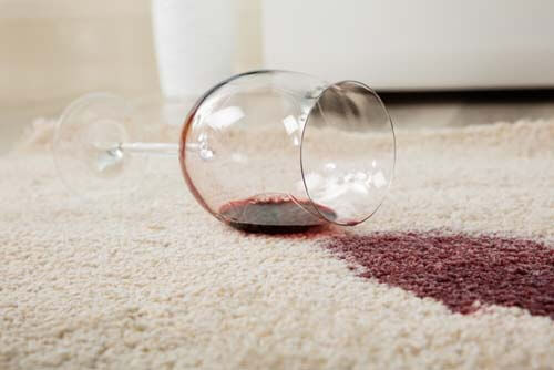 Bicchiere di vino caduto su tappeto