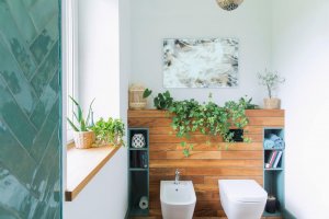 Bagno nuovo con piante e parete in legno.