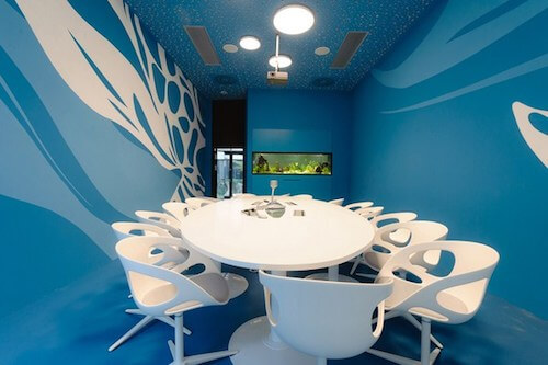 Stanza uffici microsoft con tavolo e sedie bianche e pareti blu