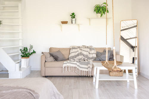 soggiorno con divano e piante in stile urbano funzionale