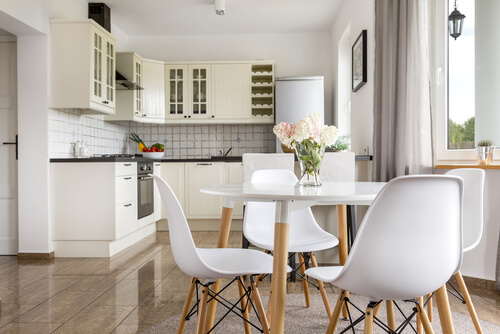 Decorare appartamento per studenti. Cucina bianca con pavimento in pseudo legno.
