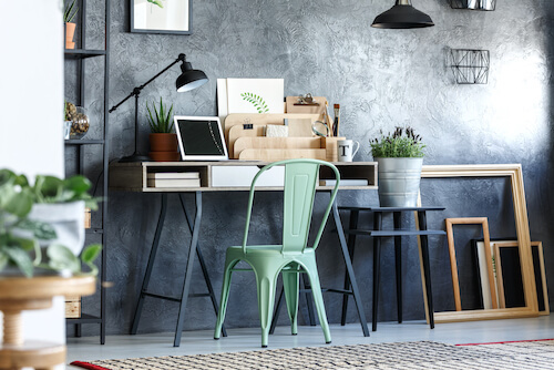 tavolo scrivania con piante sedia in ferro e parete grigia