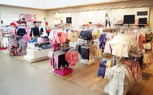 interno negozio di abbigliamento per bambini con vestiti in esposizione