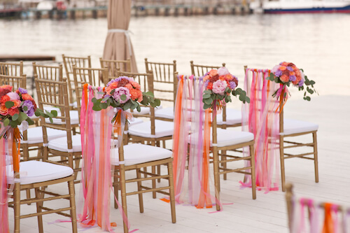 sedie bianche con decori color salmone per un matrimonio