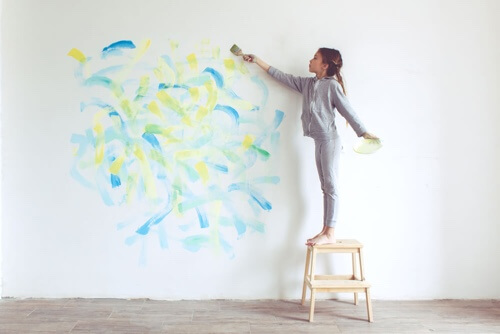 Bambina che dipinge una parete.