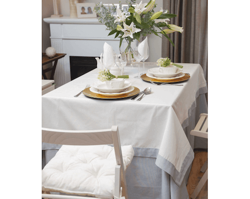 tavoli modello camilla tavolo apparecchiato con tovaglia bianca e azzurro e centrotavola con fiori